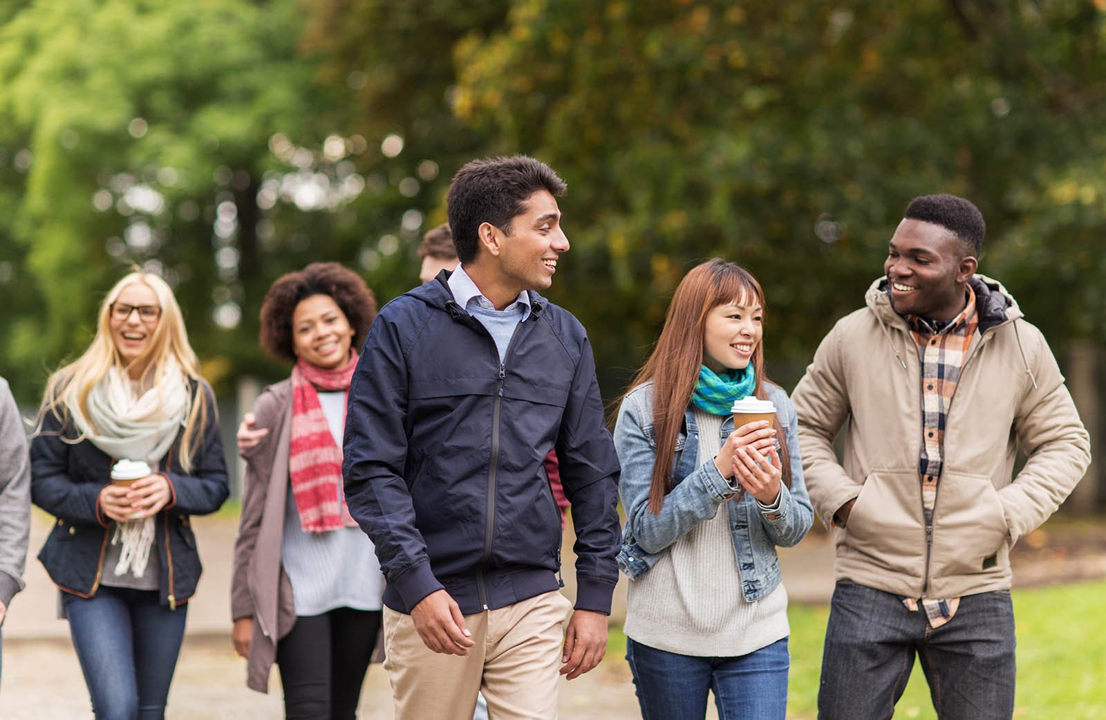 stock-photo-people-friendship-communication-and-international-concept-group-of-happy-friends-walking-along-572918770